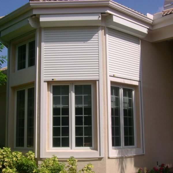 rolling shutters for windows on tan house