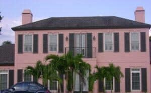 colonial hurricane shutters on a pink home in fort myers