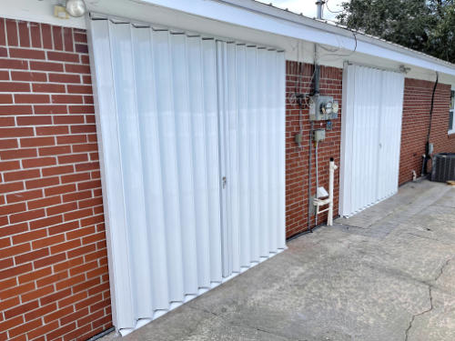 accordion security shutters on patio doors of brick house