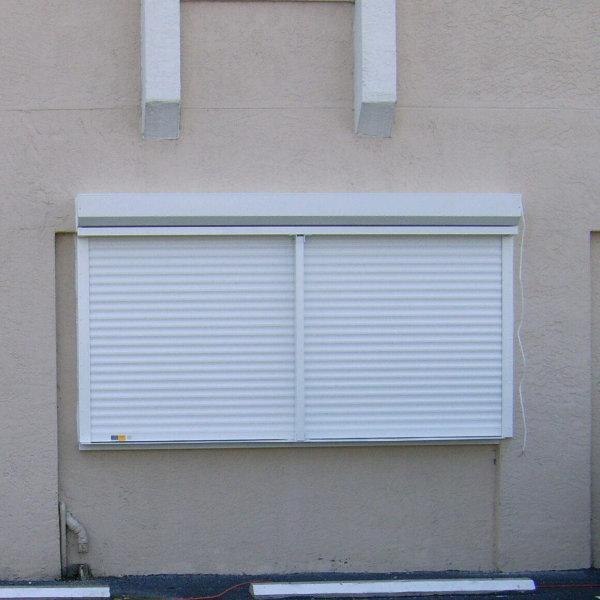 A white roller shutter shown on a window of a commercial building