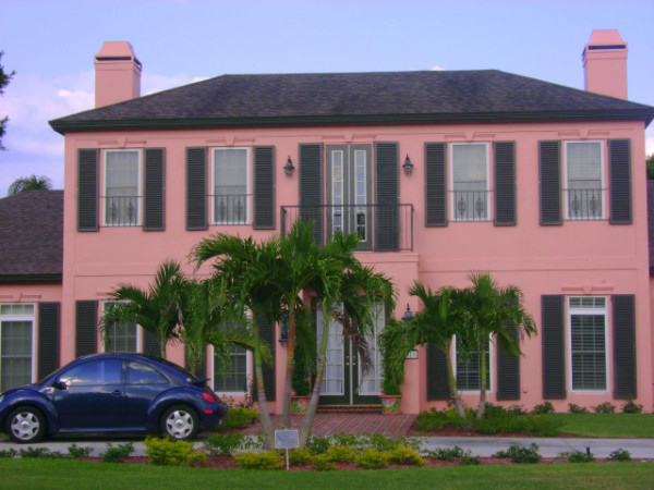 Black colonial shutters shown on a salmon colored home in Southwest Florida.