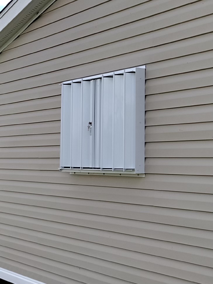 white eurex shutters ptx accordion shutters shown on tan home in lehigh acres fl