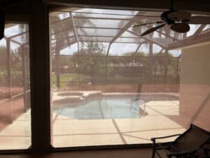 View through hurricane screens looking out to pool