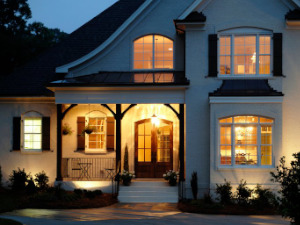 White double-hung impact windows shown on exterior of a tan home at night
