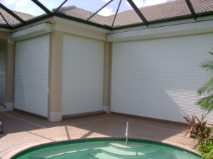 white roll down shutters on tan house