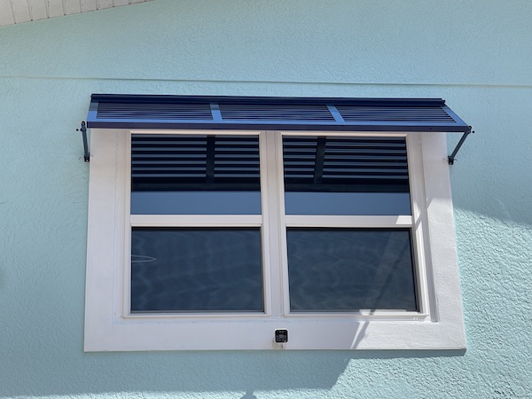 Deco Bahama Shutters on a white, double window of a beach home in Fort Myers Beach FL