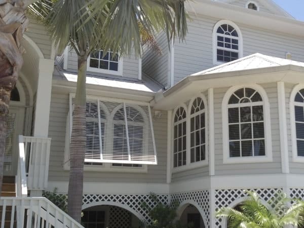 White bahama shutters go perfectly on this tan beach home. 