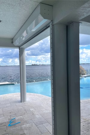 White roll down hurricane shutters on a patio overlooking pool and river in Cape Coral FL. 