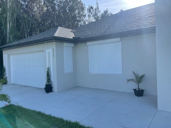 White roll down shutters shown on a home in Lehigh Acres Florida.