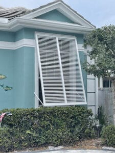 White bahama shutters on a blue home.