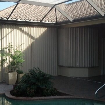 Beige accordion shutters on a tan home in Southwest Florida