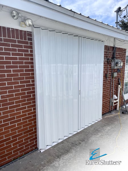 White accordion shutters shown closed on a patio door in Clewiston FL