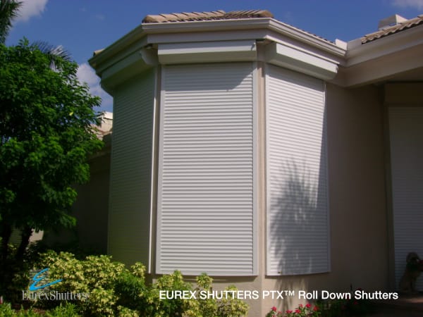White roll up hurricane shutters installed and closed on several windows of a home in Florida
