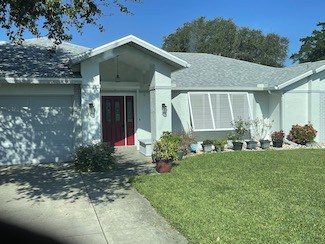 Bahama shutters on a green home in Lehigh Acres FL