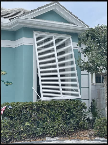 White aluminum Bahama shutters installed on a home in Englewood Florida