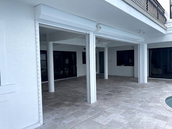 White roll up shutters on a patio pool deck near a pool in Cape Coral FL