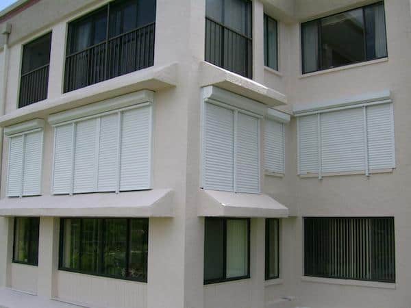 White rolling shutters on commercial building windows. 