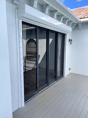 White rolling shutters installed over sliding glass doors in Cape Coral FL