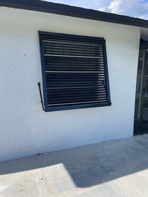 A newly installed custom, black Eurex Shutters Bahama Hurricane Shutter on a home in Lehigh Acres