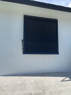 A newly installed custom, black Eurex Shutters Bahama Shutter on a home in Lehigh Acres