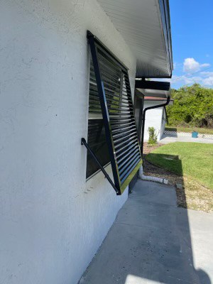 Side profile of a newly installed custom, black Eurex Shutters Bahama Hurricane Shutter on a home in Lehigh Acres