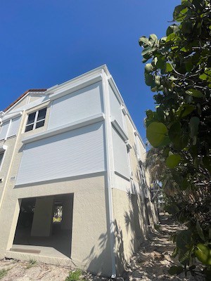 White roll down hurricane shutters covering the windows of a condo in Sanibel FL