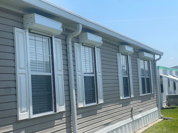 White Eurex Shutters Roll Down Hurricane Shutters on the windows of a beige manufactured home in South Fort Myers FL
