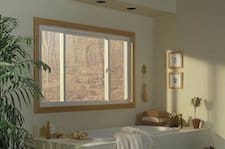 white, aluminum frame sliding, horizontal roller window with impact glass installed in a bathroom above a soaking tub