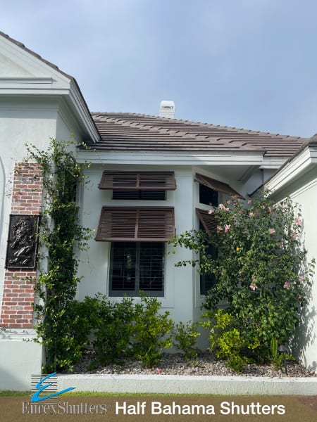 Brown half bahama shutters installed on a stucco home in Sanibel FL