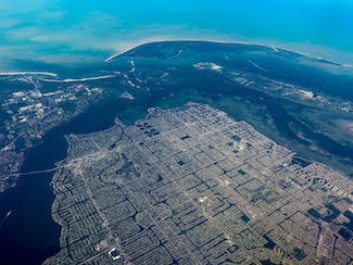 Aerial view of Cape Coral Florida showing its large number of canals and surrounded by water and location near the Gulf of Mexico, situating it in a hurricane zone