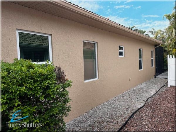 Several impact windows shown installed on the side of a home in Naples Florida