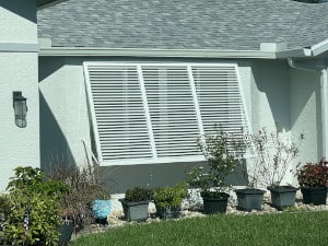 Wide, aluminum Bahama shutter shown on the window of a home in Lehigh Acres Florida.