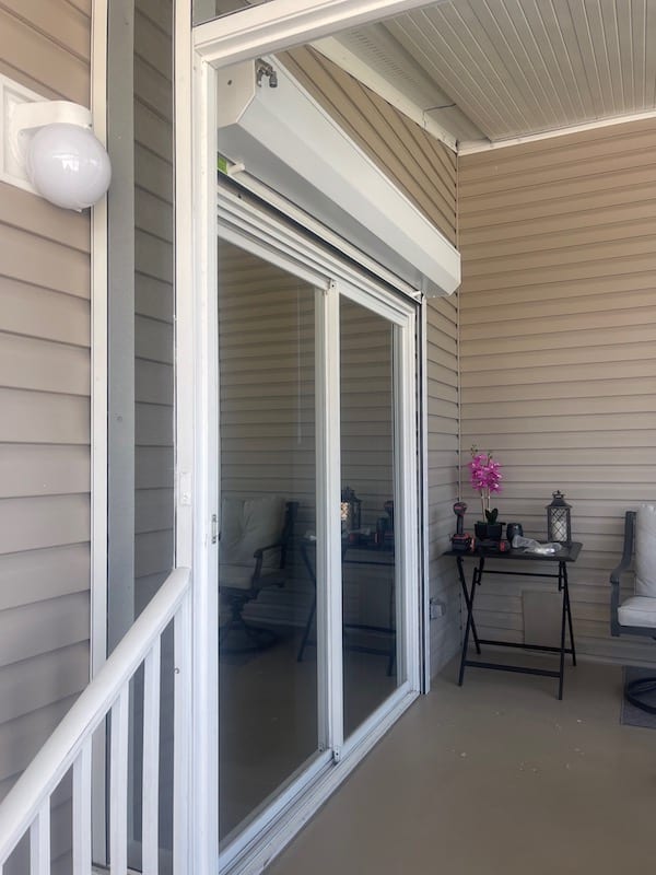 rolldown shutters shown in the open position over a double sliding door. White rolldowns shown in the open position. White slats, white tracks and white housing box