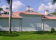 White hurricane shutters (multiple) on the front of a beige home