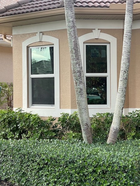 White, vinyl impact windows with no grids, installed on the front of a tan home in Naples Florida