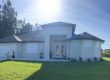 White roller shutters installed on the windows of a tan home in Lehigh Acres Florida