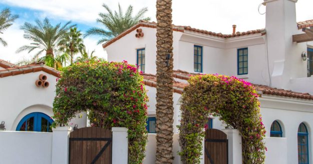 Mediterranean style home with palm trees.