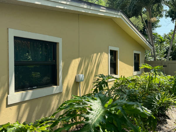 Wide, double-hung bedroom egress windows with bronze frames.
